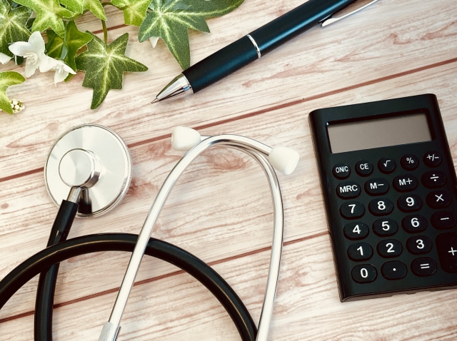聴診器とボールペンと電卓の画像
