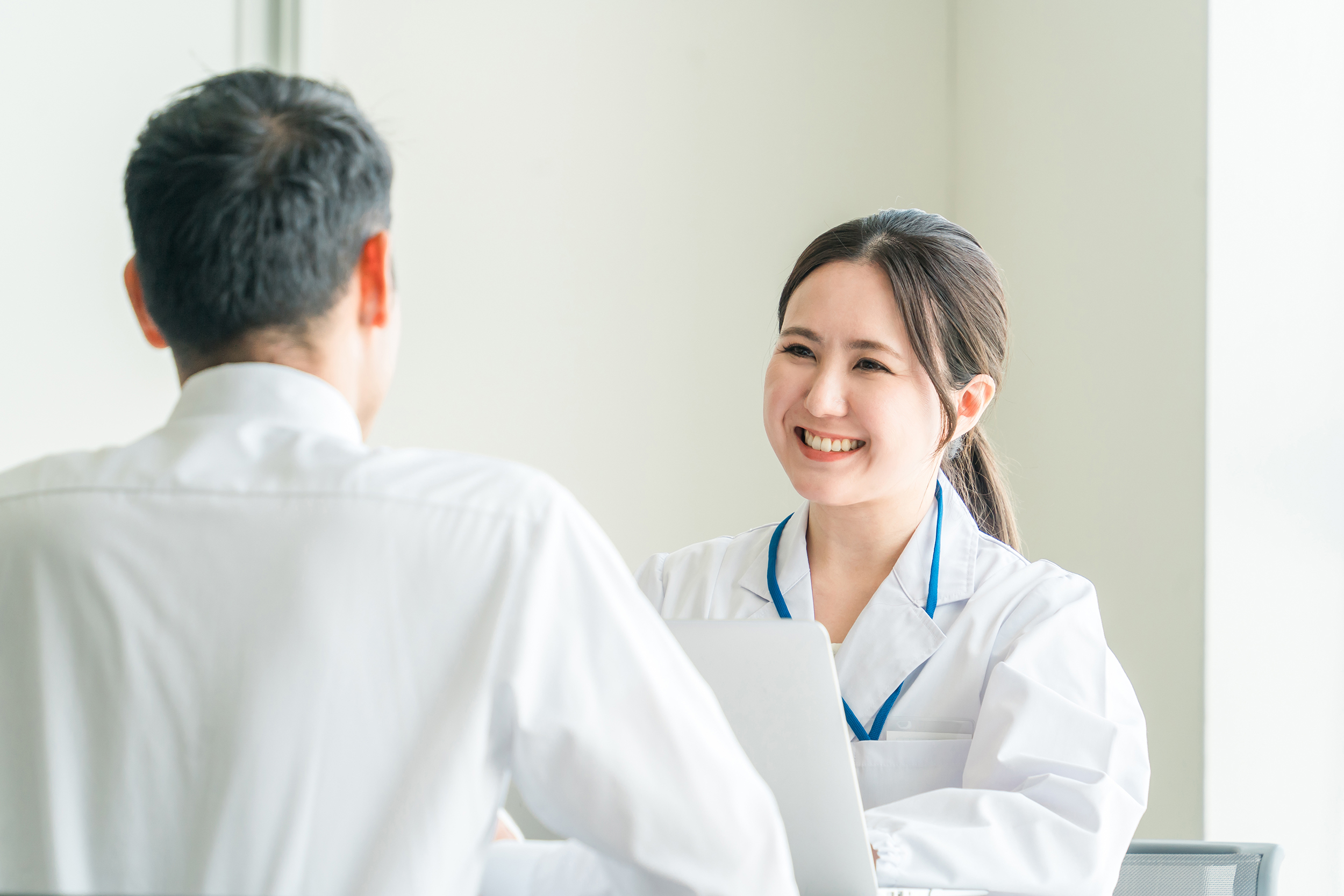 笑顔で対応する白衣女性の画像